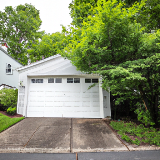 Suburban Voorhees home with a modern sectional garage door, driveway and seasonal greenery in soft daylight.